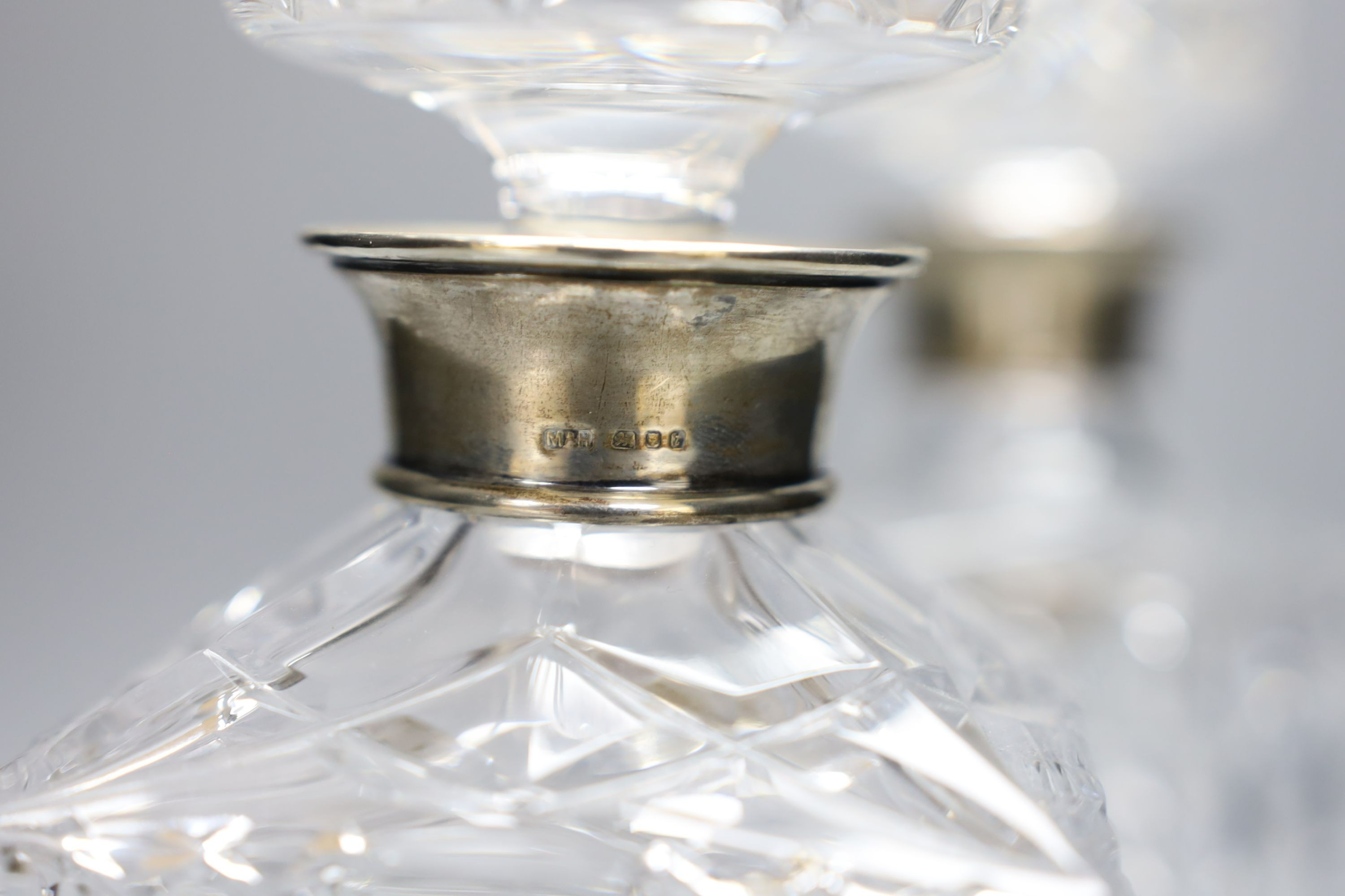 A pair of silver mounted cut glass decanters and stoppers, 23.5cm